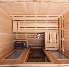 the inside of a wooden sauna with two benches and a heater in it