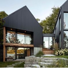 two modern houses with large windows and stone steps leading up to the second story area