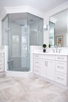 a white bathroom with two sinks and a walk in shower