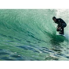 a man riding a wave on top of a surfboard