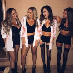 three women dressed up as zombies in front of a mirror with their arms around each other