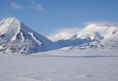 two people on skis in the snow with mountains in the backgrounnd