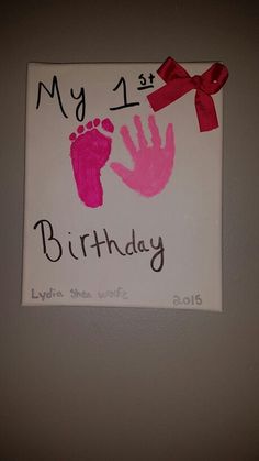 a hand and foot print on a birthday card with a red ribbon tied around it