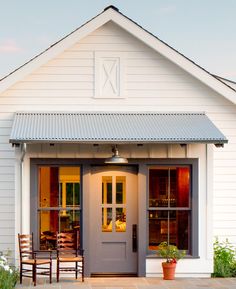 a small white house with a gray front door