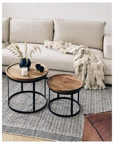 two tables sitting on top of a rug in front of a couch