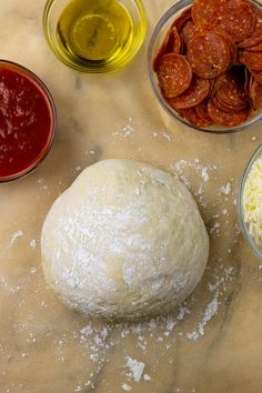 ingredients for pizza dough laid out on a counter top, including olives and cheese