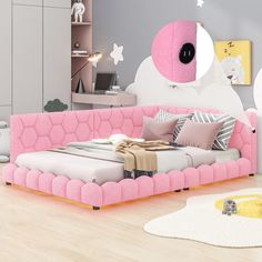 a pink bed sitting on top of a hard wood floor next to a white rug