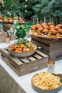 a table topped with plates and trays filled with food