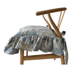 a chair with a ruffled seat cover on it's back and wooden legs