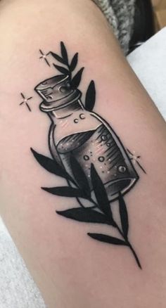 a black and white photo of a tattoo with a bottle on it's arm