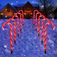 several candy canes are lit up in the snow