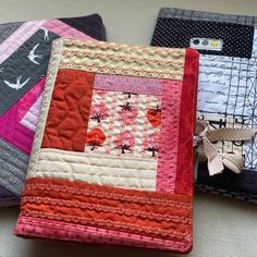 three quilted wallets sitting next to each other on a table