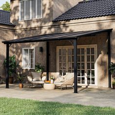 a patio covered with furniture and plants in front of a house