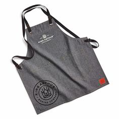 the apron is made out of denim and has an embroidered logo on it, which reads king & country