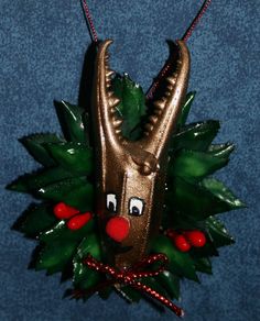 an ornament shaped like a reindeer's head with holly leaves and red berries