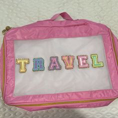 a pink bag with the word travel embroidered on it