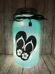 a mason jar with flip flops painted on it