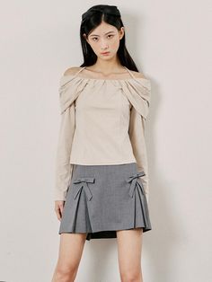 This is a structured A-line skirt featuring a textured fabric and a clean, seamless waistband. It is designed with two large, symmetrical bows on the front which add a playful yet sophisticated element to its style. The skirt has a discreet zipper closure at the back for a smooth fit. The overall design of the skirt combines a classic silhouette with a modern, decorative twist.- The bows provide a unique detail that enhances the skirt's aesthetic, offering both visual interest and a touch of femininity.- Its A-line cut is flattering for various body types, making it a versatile piece for different occasions.- The skirt's material and design suggest it could be a choice for professional settings as well as social events. Elegant Beige Party Skort, Chic Beige Flared Skort, Elegant Fitted Mini Skirt With Bow, Chic Mini Skirt With Bow Detail, Chic Mini Skirt With Bow, Flared Skirt With Bow Detail, Chic Bow Mini Skirt For Spring, Elegant Spring Mini Skirt With Bow, Chic Bow Mini Skirt For Summer