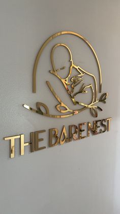 the sign for the baby's nursery is made out of gold and black metal