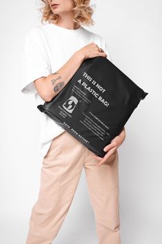 a woman holding a black bag with the words, they're not a plastic bag