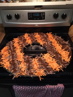 a cake sitting on top of an oven covered in frosting