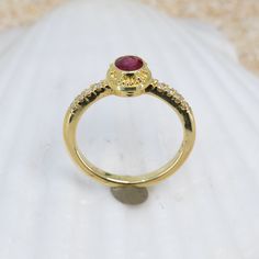 Treat yourself to an exquisite adornment handcrafted in 18K granulated gold, showcasing a stunning ruby and glittering diamonds, to add a hint of sophistication and charm to any outfit. The classic simplicity of this Ruby & Diamond Classical Ring will add an elegant allure to your jewelry collection. Featuring a dazzling 0.58ct ruby accented with 0.1cttw of 1.5mm VS/GH diamonds. Size 6, but each ring comes with free sizing and FREE SHIPPING! Watch a video of this ring being made HERE Unsure what Formal Yellow Gold Ruby Ring With Pave Setting, Elegant Yellow Gold Ruby Ring With Pave Setting, Ruby Rings With Pave Setting, Gold Ruby Jewelry With Pave Setting, Oval Ruby Ring With Pave Setting, Oval Ruby Diamond Ring With Pave Setting, 22k Yellow Gold Ruby Ring For Anniversary, Oval Ruby Ring With Pave Setting For Weddings, Luxury Ruby Ring With Pave Setting For Wedding