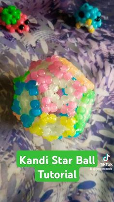 colorful beads are sitting on top of a purple table cloth with the words kandi star ball