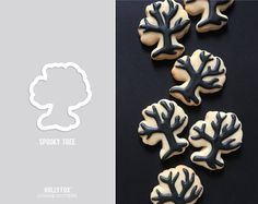 four cookies with black and white frosting on them are shown in the shape of trees