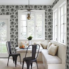 a dining room table with two chairs next to a bench and window in front of it