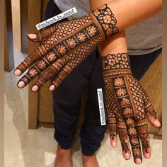 two hands with henna designs on them, one is black and the other is brown