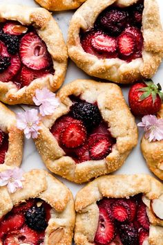 strawberry hand pies with almond crust and fresh berries in the middle on a white surface