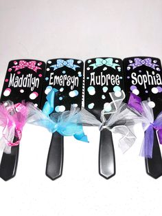 three spoons with bows on them sitting next to each other in front of a white background