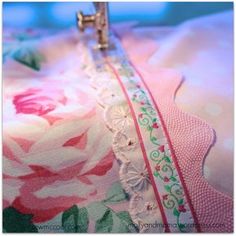 the sewing machine is on top of the pink and green floral print fabric that has been stitched together