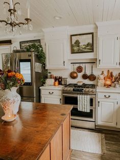 a kitchen filled with lots of white cabinets and wooden counter tops next to a stove top oven