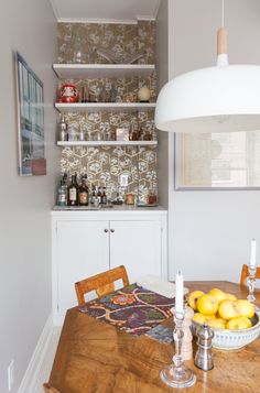 a dining room table with some lemons on it and bottles in the back ground