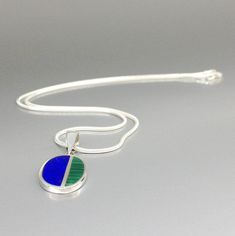 "Oval modern pendant Lapis lazuli and Malachite set in Sterling siver with silver chain. Unique gift for her or him, friend, September and December birthstone, anniversary gift. Very nice classic pendant, with a modern touch. The pendant is divided in two parts, the bigger being Lapis and a smaller with Malachite. This beautiful pendant is worked with the technique of inlay, which means the stone is worked seamlessly into the Sterling silver. The 2.5mm loop is suitable for every chain and standa Modern Blue Necklace With Polished Finish, Modern Blue Necklaces With Polished Finish, Modern Blue Oval Necklace, Modernist Blue Jewelry As Gift, Blue Modernist Jewelry For Gift, Modernist Blue Jewelry For Gift, Modernist Blue Jewelry Gift, Work Gifts, Mens Pendant