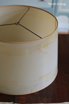 a white lamp shade sitting on top of a wooden table