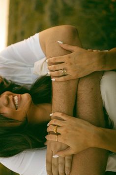 two people laying on top of each other with their arms around the woman's legs