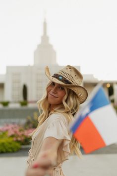 a woman wearing a hat and holding a flag