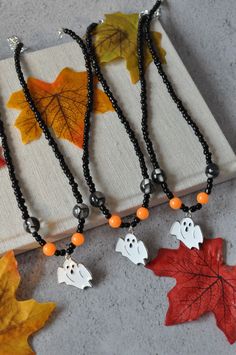 Elevate your Halloween style with our bewitching Halloween Glow In The Dark Ghost Beaded Necklace. This mesmerizing accessory captures the essence of the season in a unique and enchanting way. Crafted with meticulous attention to detail, this necklace features a charming ghost pendant surrounded by intricately designed beads. The pendant is complemented by orange beads that glow in the dark, adding a touch of mystery and allure to your Halloween ensemble. Whether you're celebrating with friends, Spiritual Halloween Festival Necklaces, Spiritual Necklaces For Halloween Festival, Handmade Spiritual Necklaces For Halloween, Spiritual Necklace For Halloween Festival, Halloween Festival Jewelry With Black Beads, Halloween Festival Black Beaded Jewelry, Halloween Gift Beaded Necklaces With Round Beads, Halloween Festival Jewelry With Round Beads, Halloween Gift Beaded Necklace With Round Beads