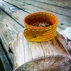 Add a touch of rustic charm to your accessory collection with this handcrafted leather cuff bracelet, featuring a natural wings grain pattern enhanced with bright yellow stitching. Carefully hand-tooled from high-quality leather, this bracelet showcases an intricate design inspired by the natural beauty of wings, blending warm browns with contrasting yellow accents to create a truly unique piece. The bracelet's embossed grain pattern is detailed and textural, giving it an organic, artisanal feel Handmade Yellow Cuff Bracelet As Gift, Handmade Yellow Cuff Bracelet Gift, Rustic Cuff Bracelets Handmade, Rustic Handmade Cuff Bracelets, Handmade Rustic Cuff Bracelet, Adjustable Yellow Cuff Bracelet As Gift, Adjustable Yellow Cuff Bracelet For Gift, Yellow Leather Jewelry For Gifts, Hand-stitched Cuff Bracelet As Gift