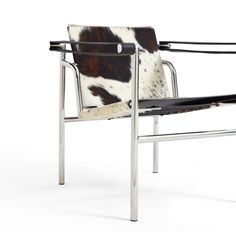 a cowhide chair with chrome frame and black leather upholstered armrests