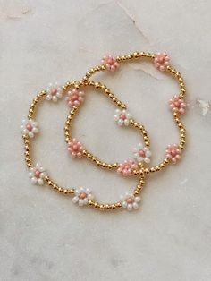 These are the most adorable daisy beaded bracelets made with your choice of gold filled or gold-plated beads and choice of pink or white daisy's. The daisies are made out of Czech Glass Beads and are perfectly dainty and adorable, especially for spring! Additional option is to just do seed beads, rather than gold plated or gold-filled beads. Pink And Gold Beaded Bracelet, Pink And White Beaded Bracelets, White And Gold Beaded Bracelet, Daisy Beaded Bracelets, Trendy Beaded Jewelry, Spring Bracelets, Glass Bead Jewelry, Pink Beaded Bracelets