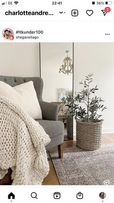 a room with a couch, chair and rug on the floor in front of a mirror