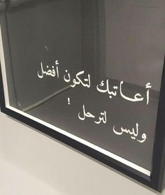 a black and white photo with arabic writing on the glass in front of a window