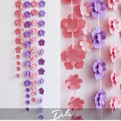 paper flowers are hanging on the wall next to each other in pink, purple and lavender colors