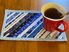 a cup of coffee sitting on top of a table next to a piece of cloth