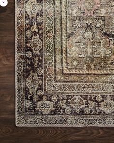 an area rug with various colors and patterns on it, sitting on a wooden floor