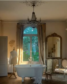 an old fashioned bathtub sits in front of a large window