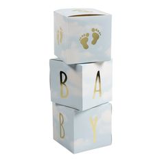 three blocks with the words baby and footprints on them in gold foil lettering, against a white background